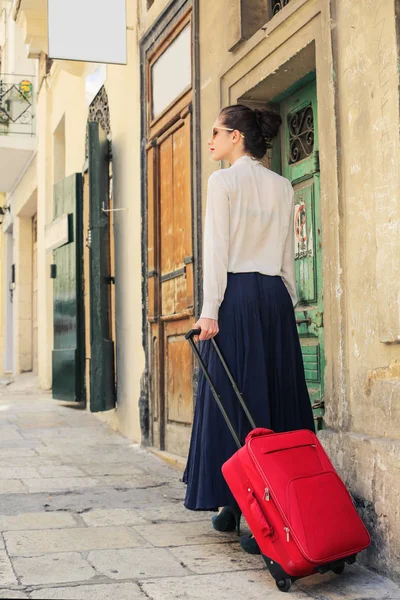 Elegante Mujer Caminando Por Una Calle Con Equipaje Rojo — Foto de Stock