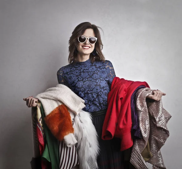 Mulher Branca Sorrindo Com Óculos Sol Segurando Algumas Roupas Coloridas — Fotografia de Stock