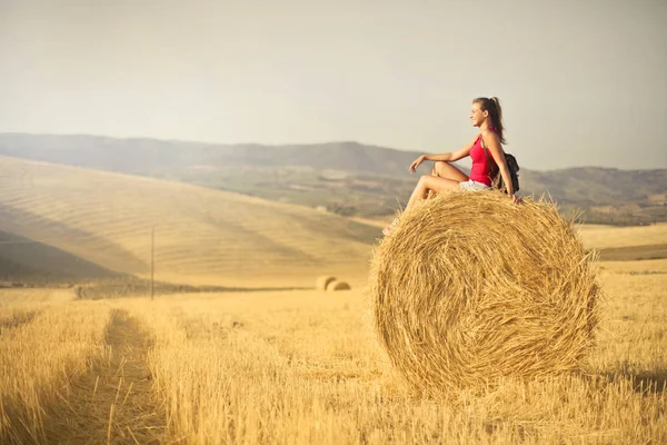 田舎で芒ボールを座っていた若い女性 — ストック写真