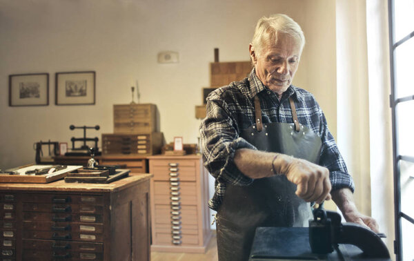Old artisan at work in his laboratory 