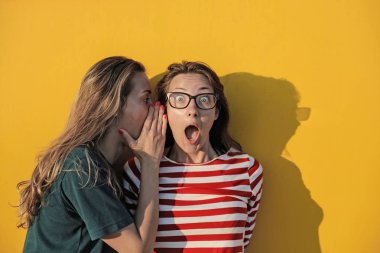 Bir diğer kız kulağına fısıldayarak kız