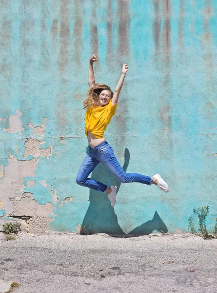 Chica Saltando Frente Una Pared Azul — Foto de Stock