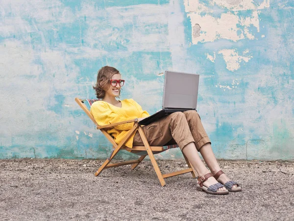 Bir Şezlong Üzerinde Bir Bilgisayar Kullanan Kız — Stok fotoğraf