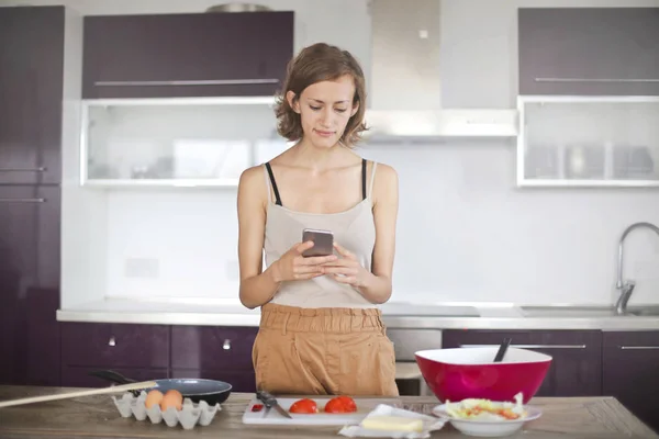 Meisje Bereiden Van Sommige Voedsel Het Gebruik Van Een Smartphone — Stockfoto