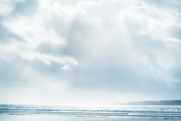 Beach and sea with cloudy sky and sunbeams. — Stock Photo, Image