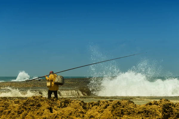 Fisherman at the sea against blue sky. — Stock Photo, Image