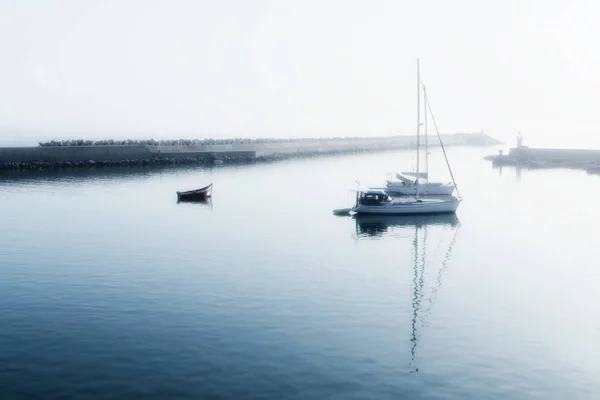 Two sailing boats (yachts) and a small motor boat anchored early — Stock Photo, Image