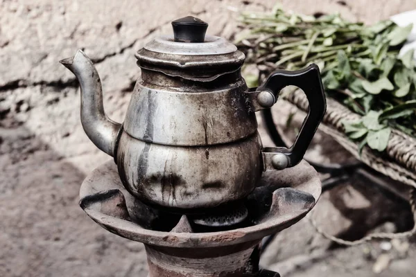 用摩洛哥薄荷做的旧生锈的茶壶 带有薄膜颗粒的复古图像 图库图片
