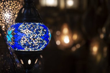 Mavi cam mozaik dizaynlı renkli Fas lambası. Doğulu tarzı. Bokeh arka planına karşı.