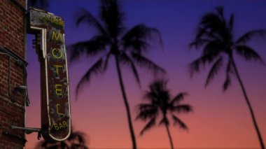 Tropikal Palmiye ağaçlarının önünde parlayan bir Retro Motel tabelası