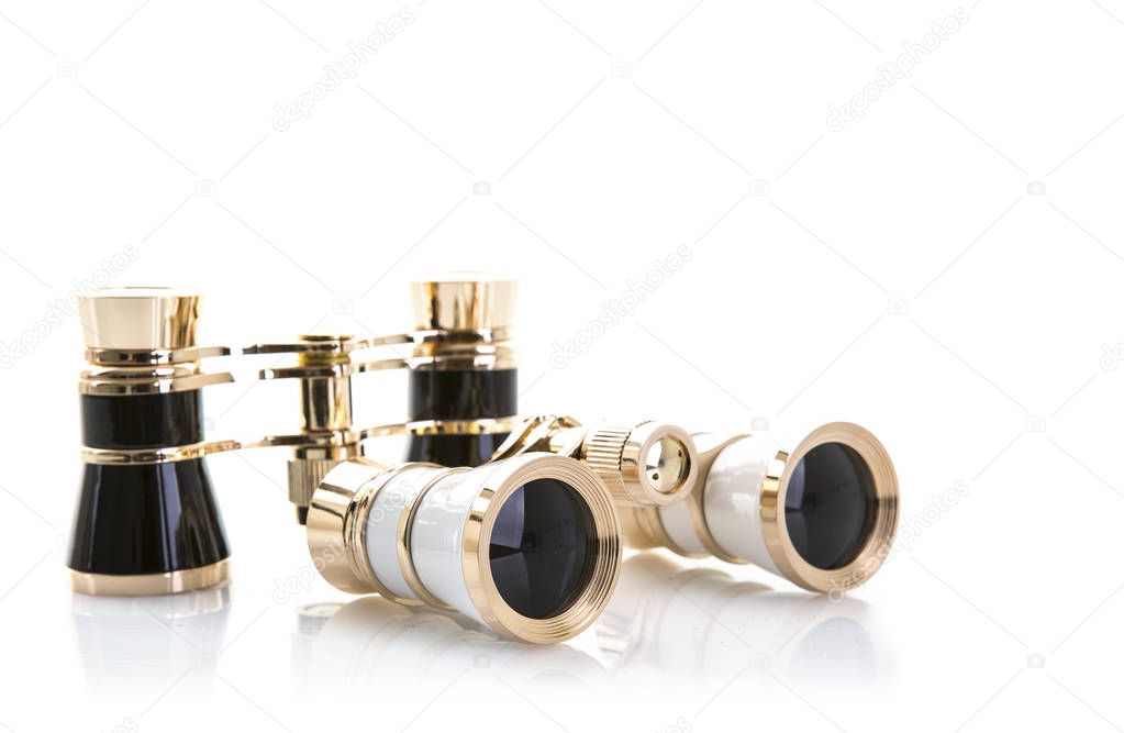 Two Pairs of opera glasses on a white background with reflection