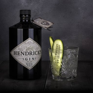 Swindon, İngiltere - 27 Aralık 2017: 70 cl şişe Hendricks distile cin rustik koyu arka plan üzerinde bir cam ve salatalık ile