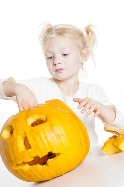 Liten flicka snidning pumpa till halloween — Stockfoto