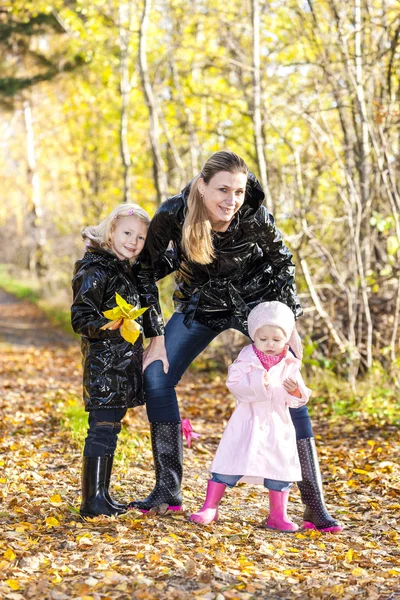 Moeder met haar dochters in de herfst natuur — Stockfoto