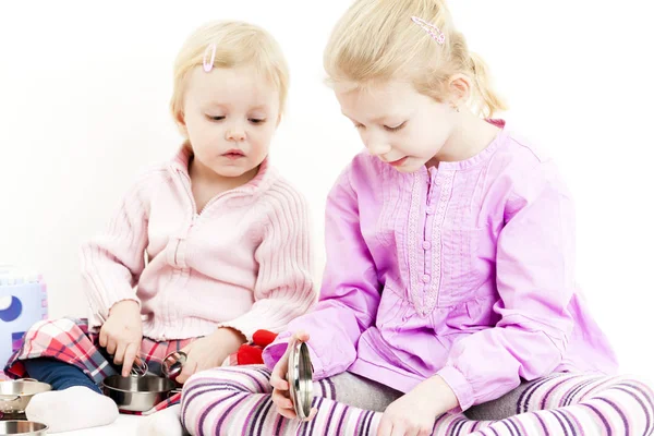 Två små flickor leker med barn maträtt — Stockfoto