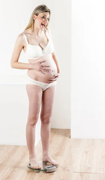 Mujer embarazada vistiendo lencería de pie — Foto de Stock