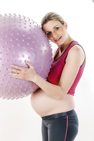 Mulher grávida fazendo exercícios com uma bola — Fotografia de Stock