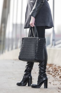 El çantalı şık siyah çizmeler.