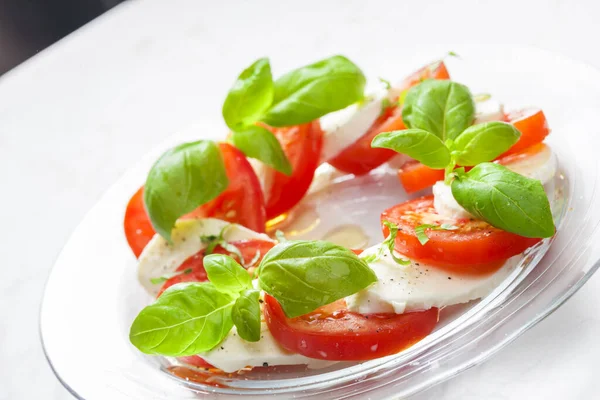 熟したトマトと新鮮なバジルの葉とモッツァレラチーズとおいしいカプレーゼサラダ イタリア料理 — ストック写真