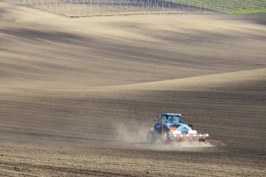 İlkbahar başlarında tohum matkabıyla traktör.