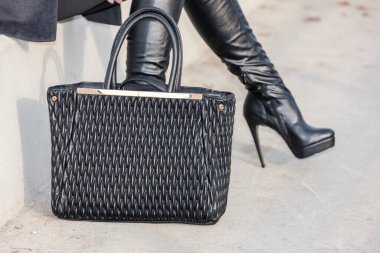 El çantalı şık siyah çizmeler.