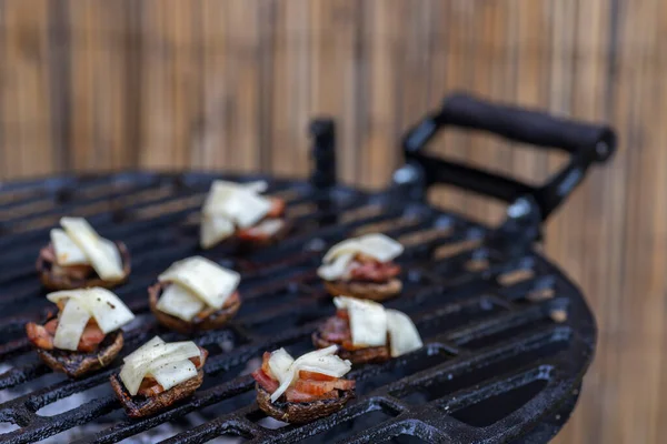 Bahçe ızgarasında pastırma ve peynirli ızgara mantar.