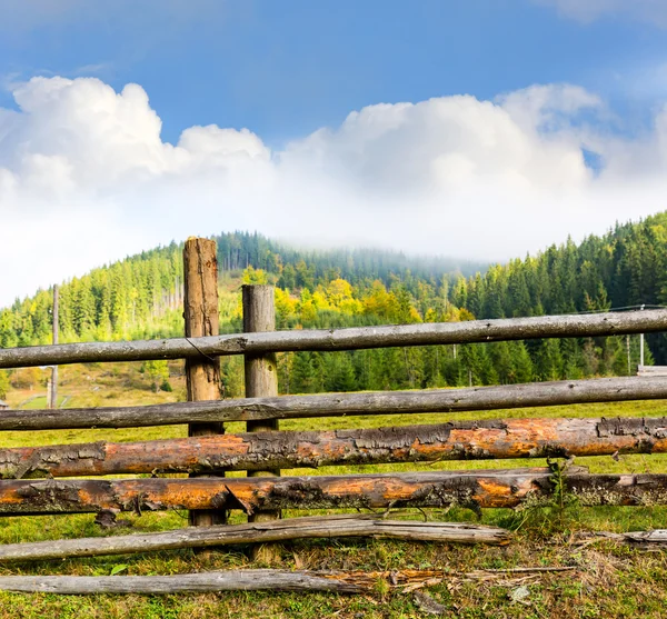 Wooden fence on mountain meadow — Stock Photo, Image