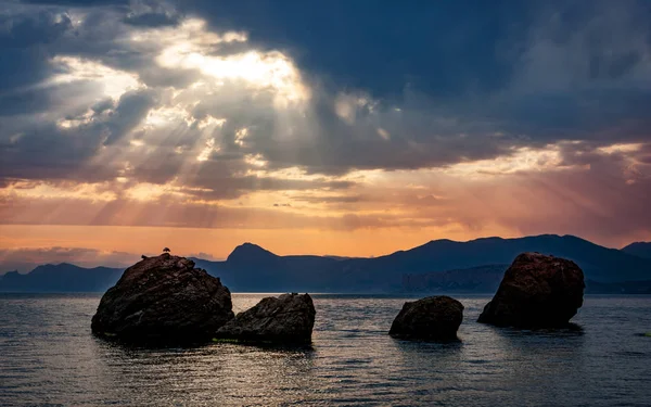 Západ slunce nad skály v moři — Stock fotografie