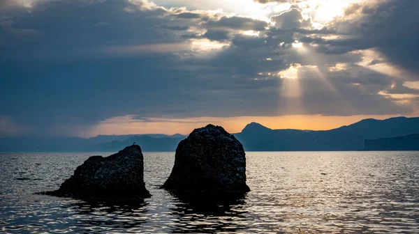 Dva kameny v moři za západu slunce na obloze — Stock fotografie