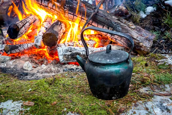 Waterkoker nabij kampvuur in bos — Stockfoto