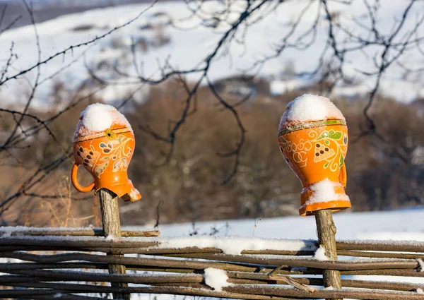 Clay jug on fence in winter time — Stock Photo, Image