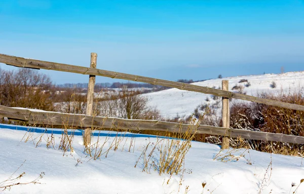 Wooden fence on winter meadow — Stock Photo, Image