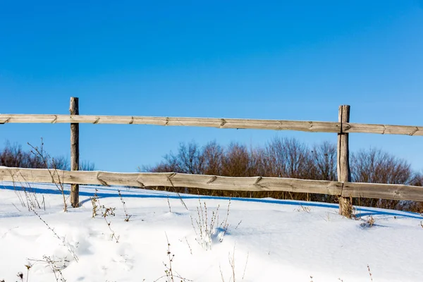 Wooden fence on winter meadow — Stock Photo, Image