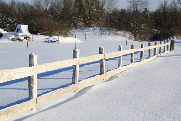 Houten hek op sneeuw bedekte weide — Stockfoto