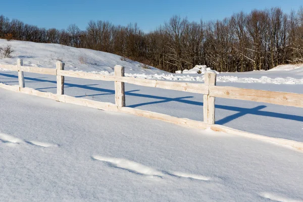 Wooden fence on winter farming field — Stock Photo, Image
