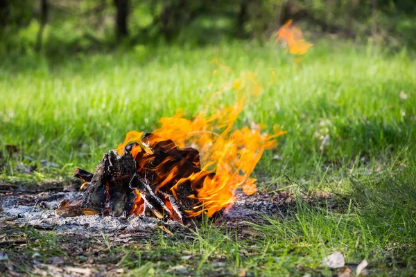 Fire in tourist camp on summer meadow — Stock Photo, Image