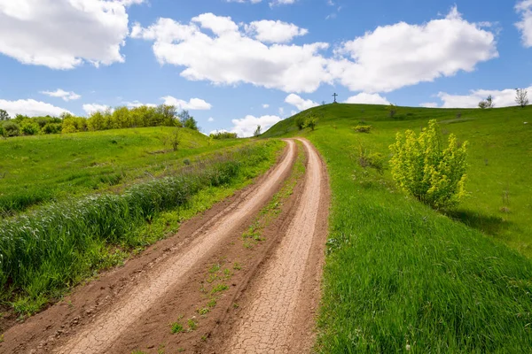 Rut road over green hill — Stock Photo, Image