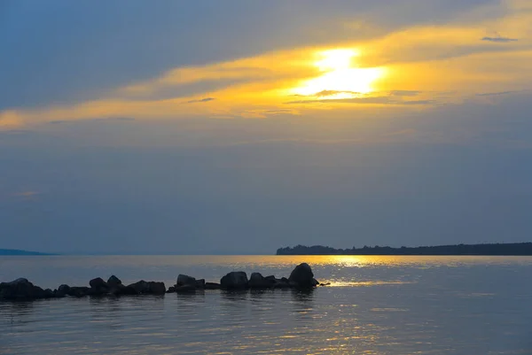 湖の表面上に水と素敵な夜の空の石と夕日の風景 — ストック写真