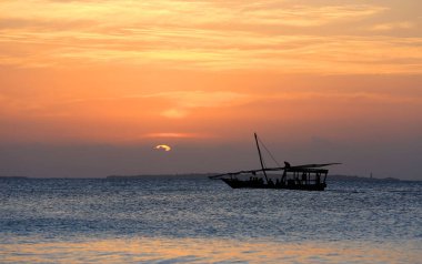 Günbatımı arka planında teknesi olan bir sahne, Zanzibar