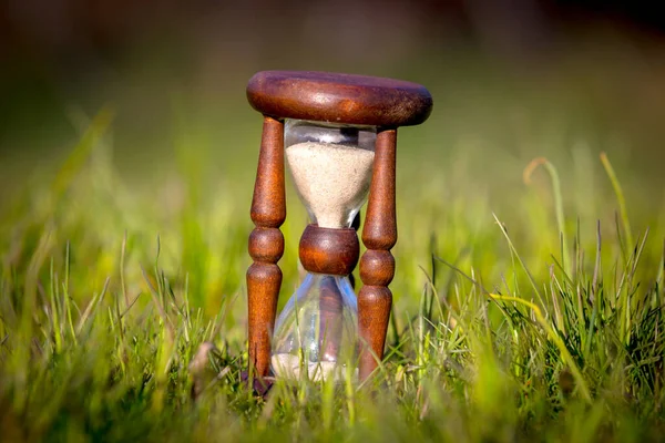 草原の緑の草の間の抽象的な古い砂時計 — ストック写真
