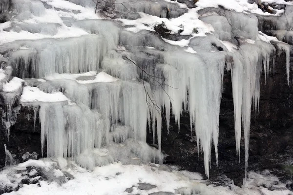 Cascade frozen waterfall in winter forest