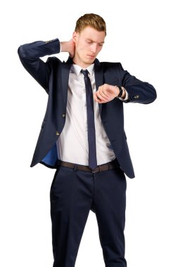 Bir takım elbise giymiş düşünceli genç işadamı saatine bakar