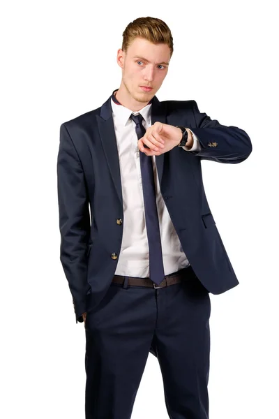 Thoughtful young businessman dressed in a suit looks at watch — Stock Photo, Image