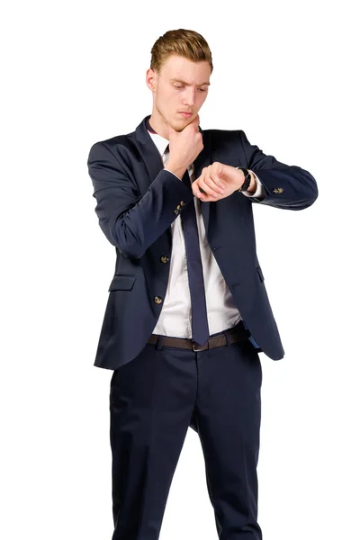 Pensativo joven hombre de negocios vestido con un traje mira el reloj —  Fotos de Stock