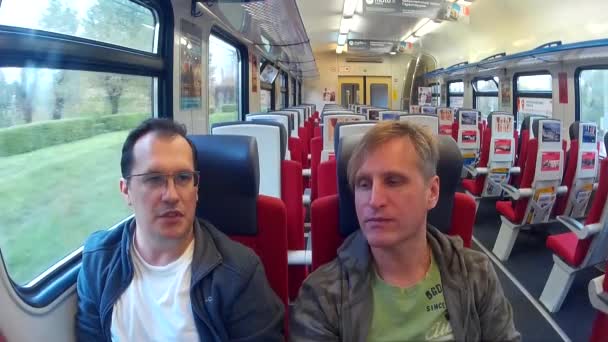 Two middle-aged men riding on a train and talking — Stock Video