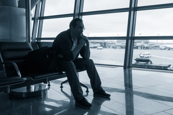 Triste hombre esperando un vuelo retrasado —  Fotos de Stock