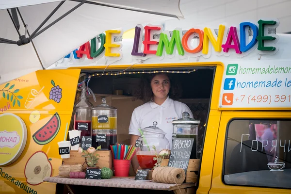 Mladá žena prodává čerstvé domácí limonády z potravinové skladby — Stock fotografie