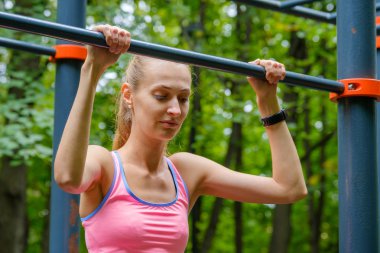 Genç ince kadın üzerinde yatay çubuk çeker