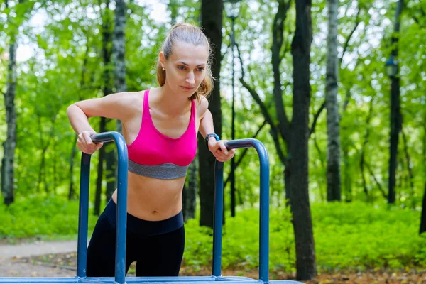 Mladá štíhlá žena, která dělá cvičení v cvičiště — Stock fotografie