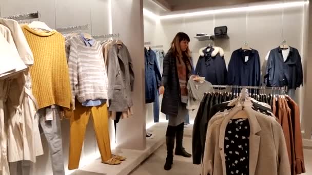 Молода жінка вибирає одяг — стокове відео